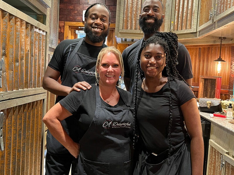 A group of people posing for a picture in a kitchen.