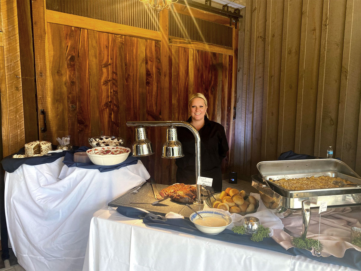 A woman standing in front of a buffet table at a corporate event.
