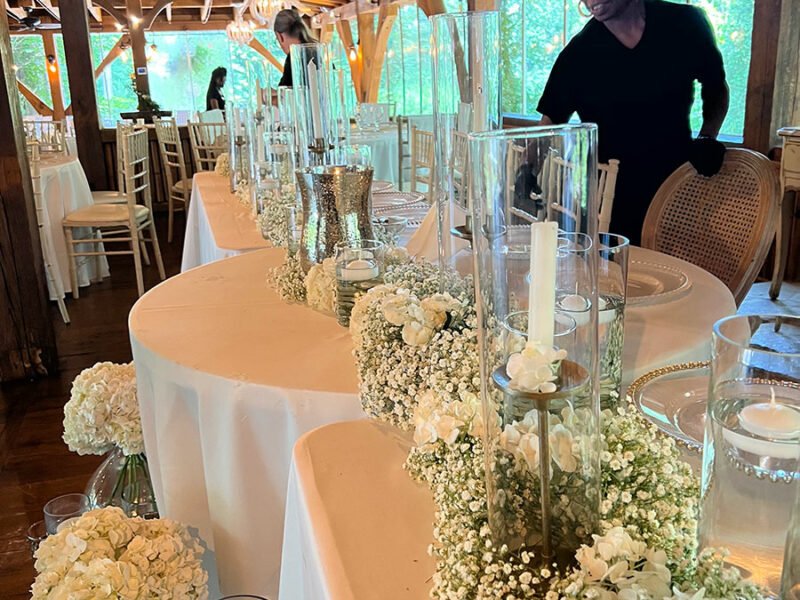 A man standing in front of a table full of flowers.