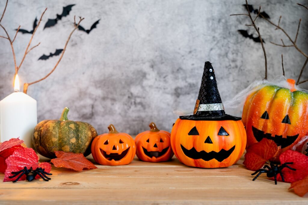 Spooky Halloween decorations on a table with candles and pumpkins for spooky party ideas.