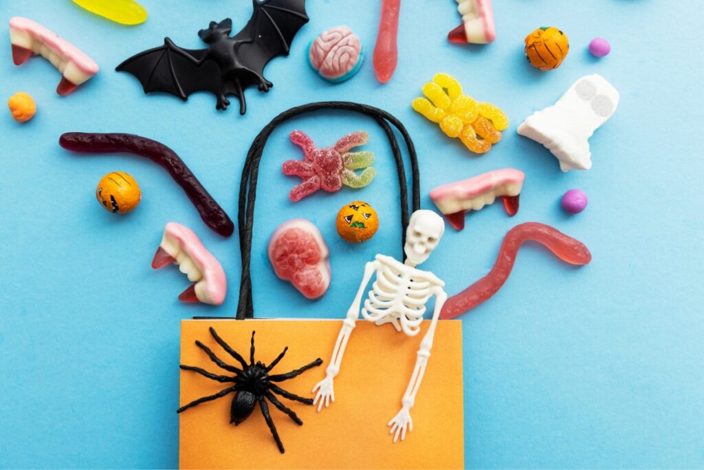 A spooky halloween bag filled with candy and skeletons.