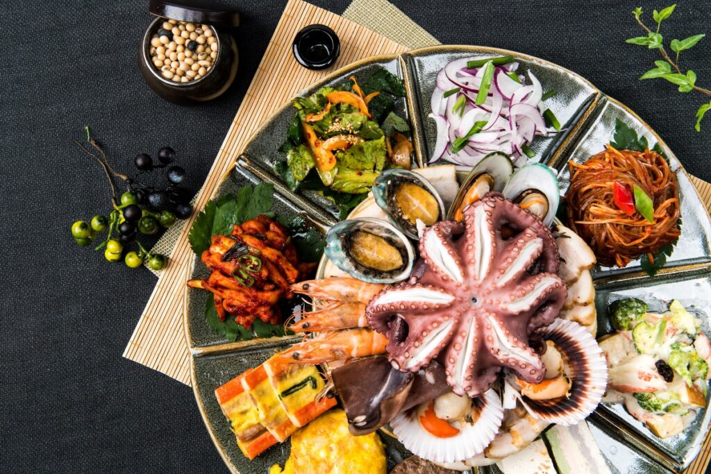 A plate with a variety of Korean food on it, showcasing Thanksgiving traditions.