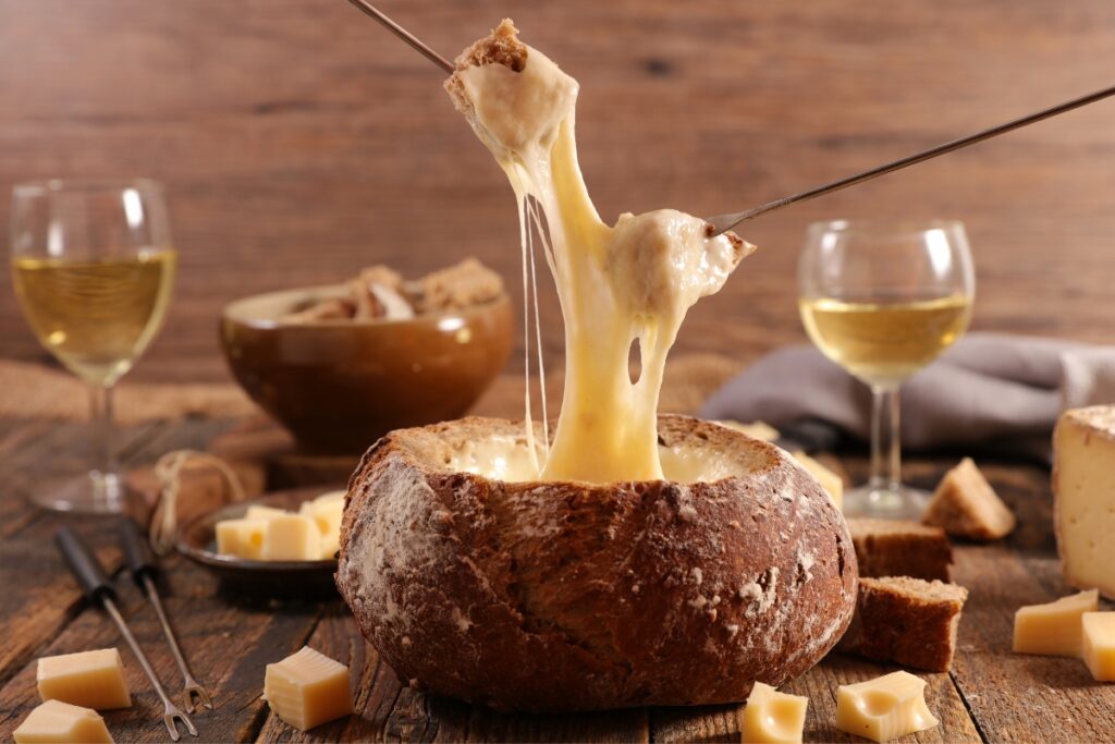 A bowl of cheese is being poured into a bowl of wine at a buffet.