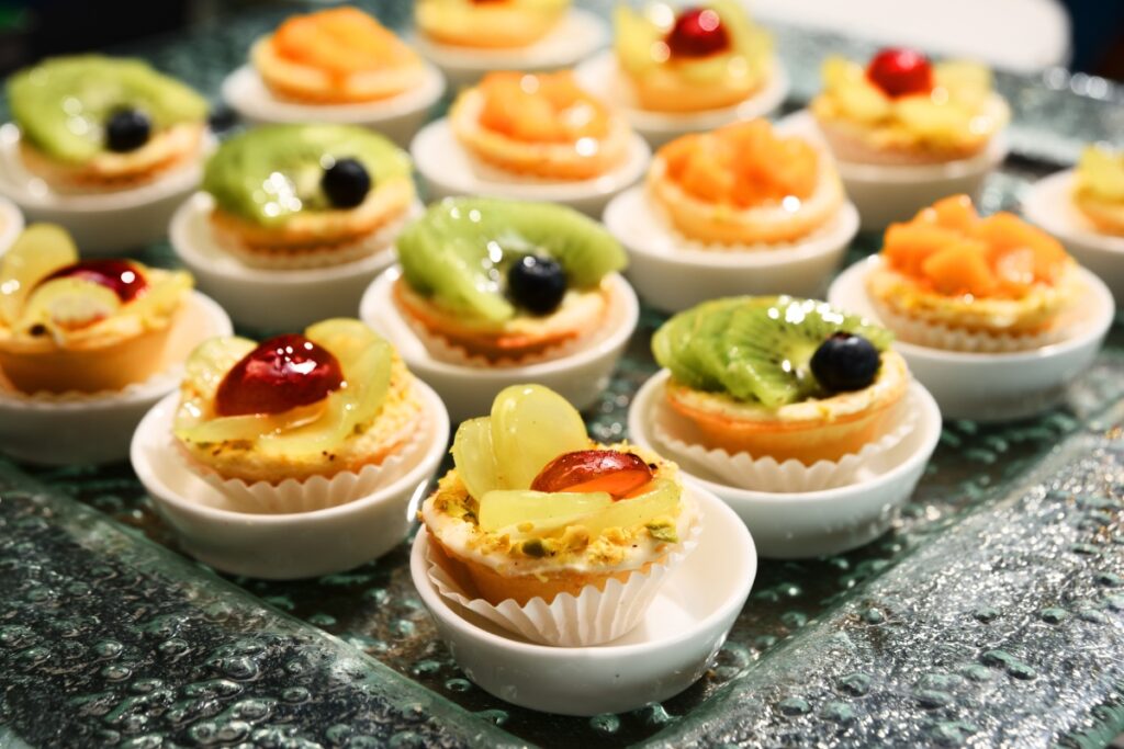 A tray of mini fruit tarts, perfect for dessert catering for parties.