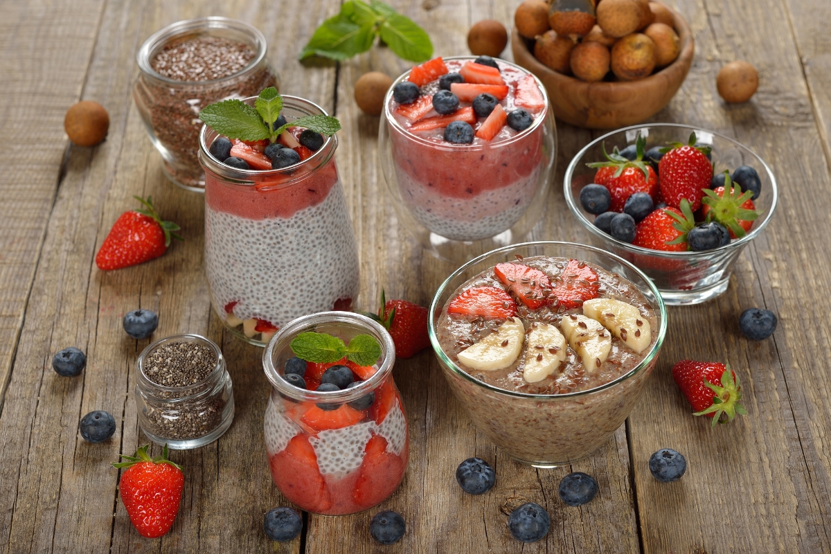 A variety of vegan chia puddings on a wooden table.