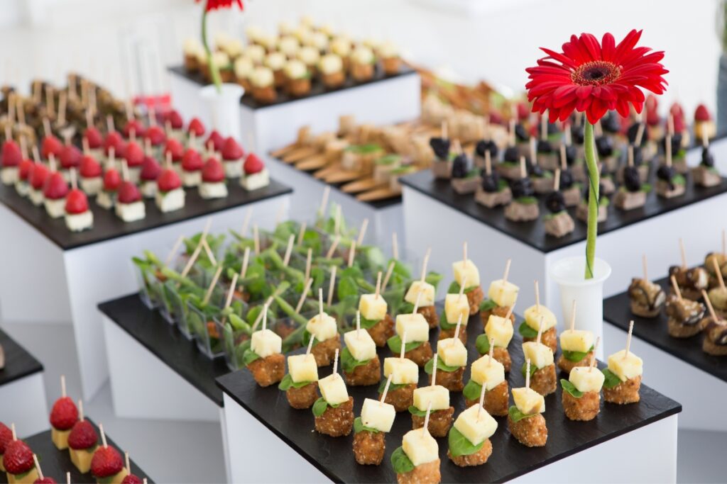 A display of appetizers on trays with a red flower in the middle, perfect for catering events.
