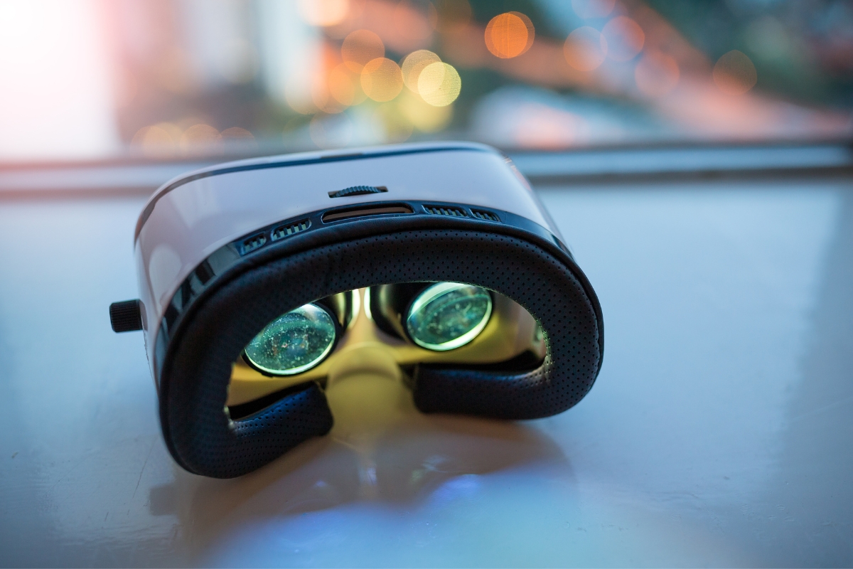 Close-up of a black virtual reality headset resting on a white surface, seamlessly blending catering technology with the future, city lights blurred in the background.