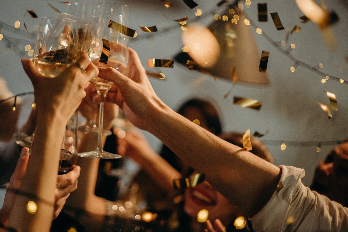 Amidst the flying confetti and string lights, expertly planned by our event planning team, people clink glasses in celebration.